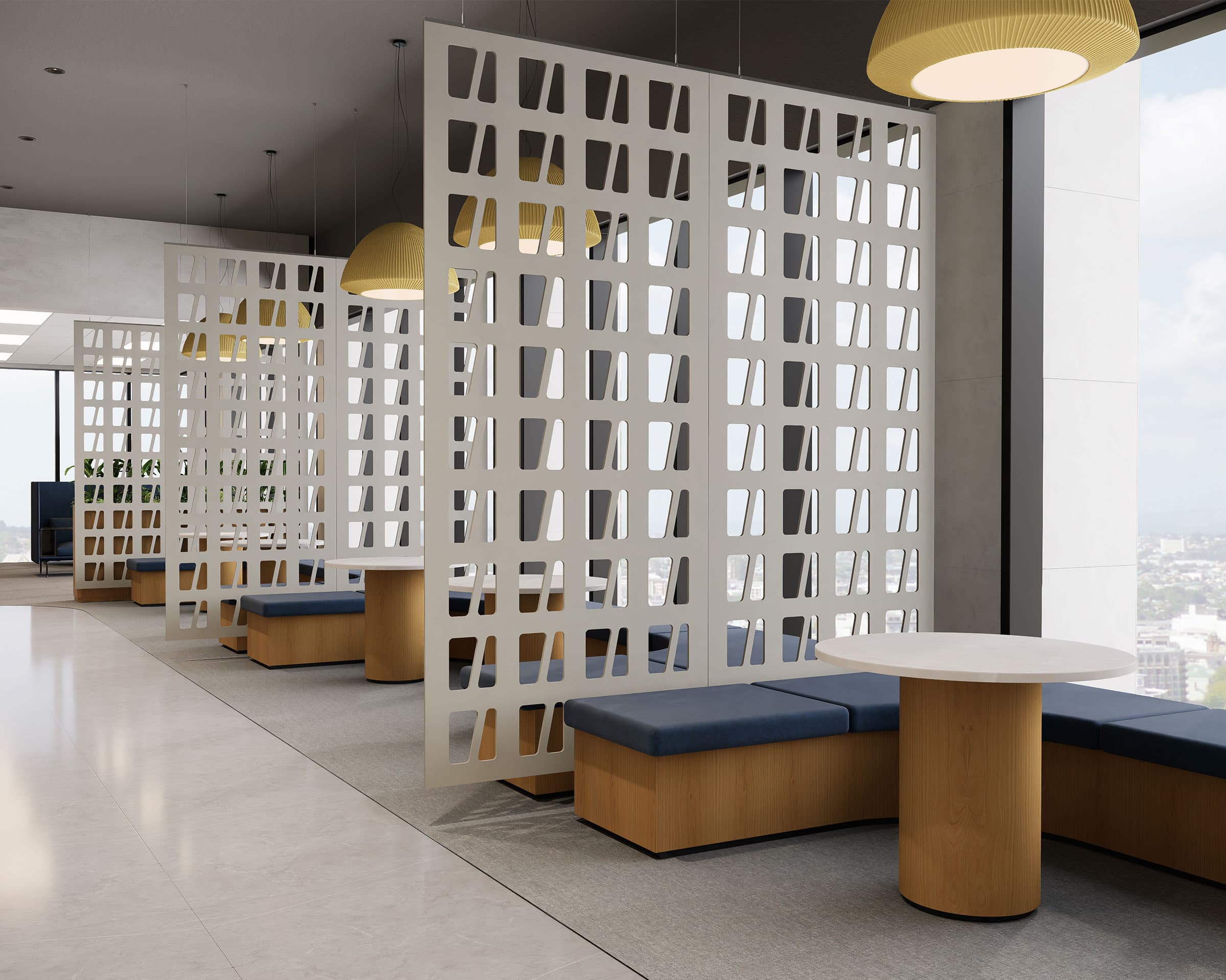 A modern and spacious office lobby features stylish seating arrangements with blue cushioned benches and circular wooden tables. The area is divided by decorative white acoustic felt screen partitions with geometric cutouts. Large windows provide a view of the cityscape outside.