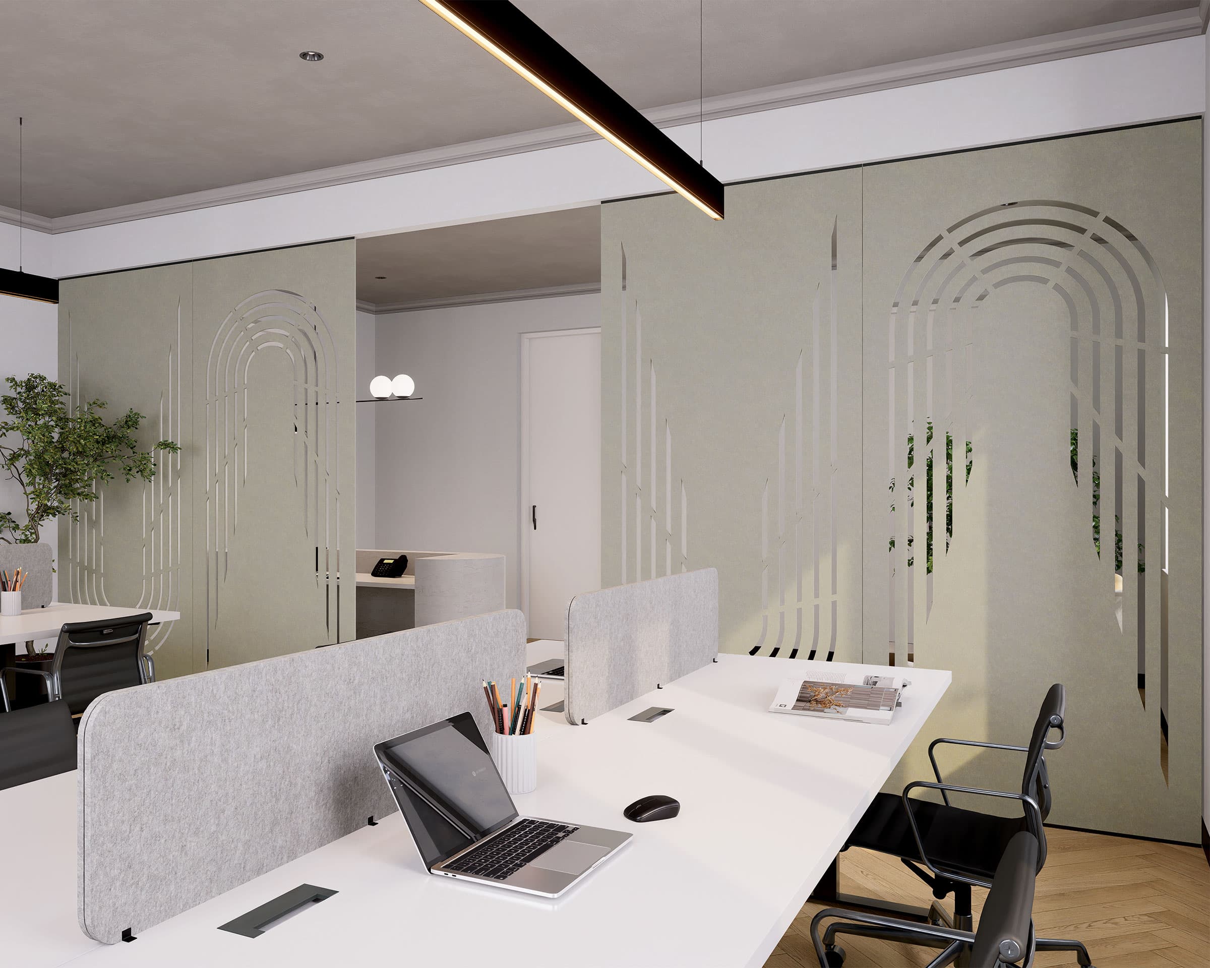 A modern office space with white desks, and ergonomic chairs. Laptops, stationery, and desk organizers are neatly arranged on the desks. The room is well-lit with recessed lighting and decorated with a potted plant and an acoustic felt screen for added tranquility.