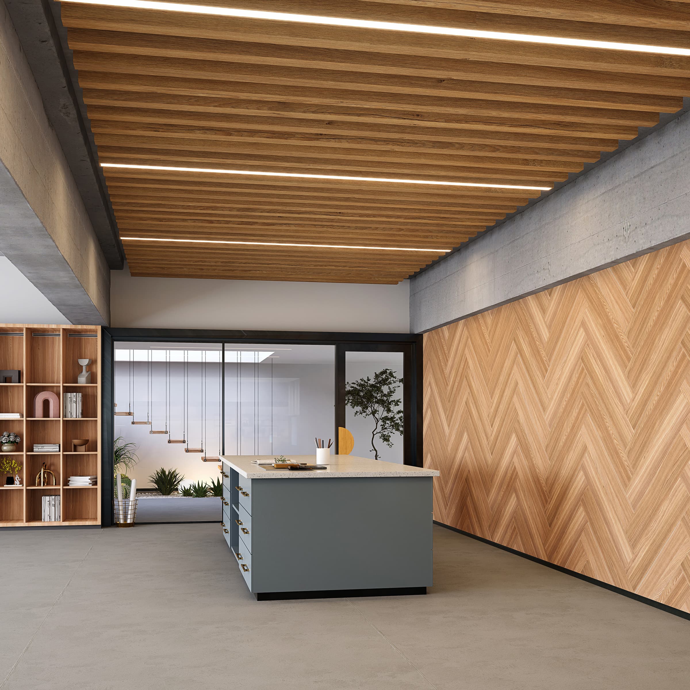 A modern workspace with a central island featuring a grey base and a white countertop. The room has a herringbone wooden wall, open shelving on the left, and woodgrain acoustic felt ceiling baffles with recessed LED lighting. Large windows reveal a staircase and greenery outside.