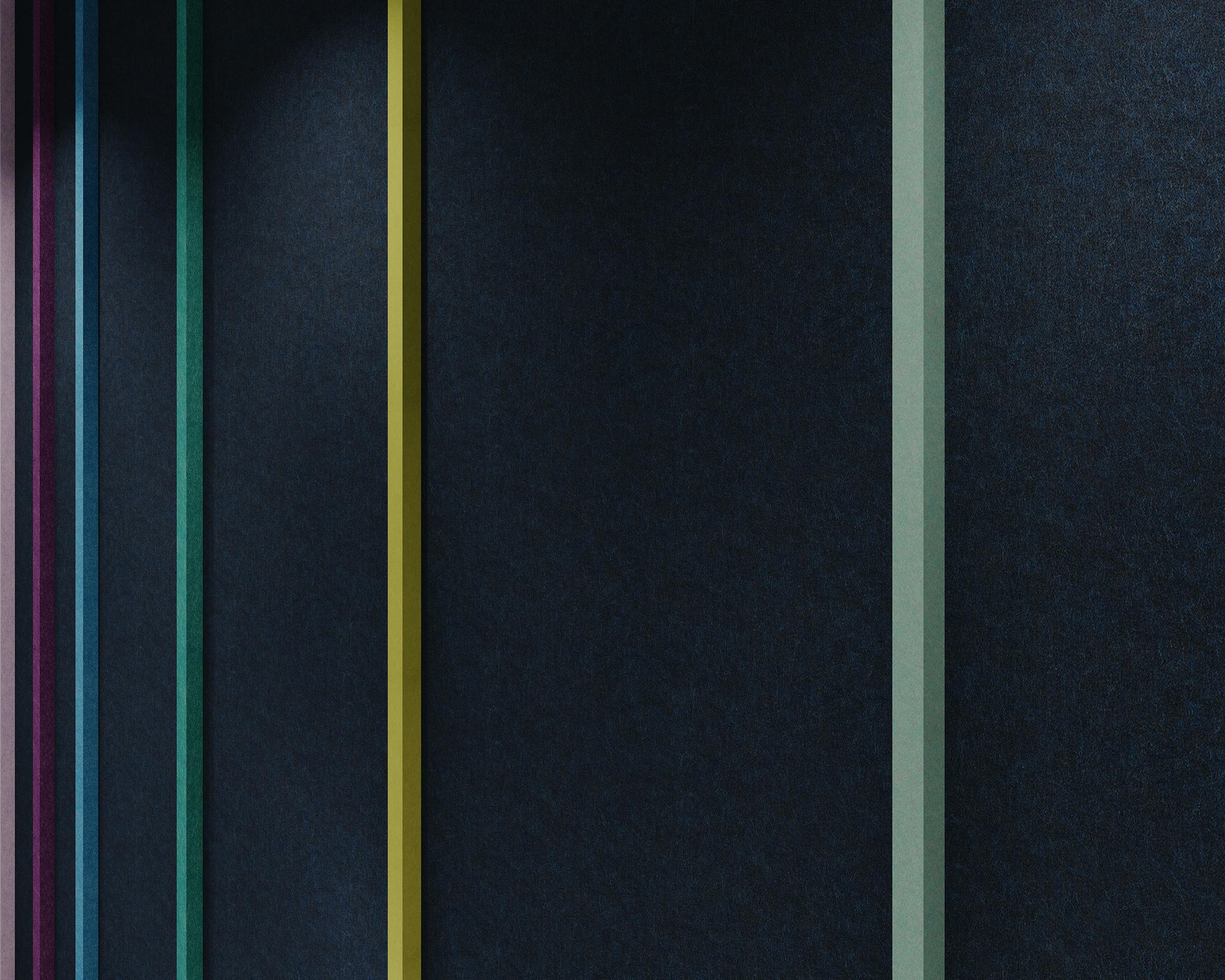 A dark acoustic felt wall with vertical stripes of different colors—purple, blue, green, yellow, and light green—spaced evenly apart. The seam between each stripe creates a visually striking pattern against the dark background.