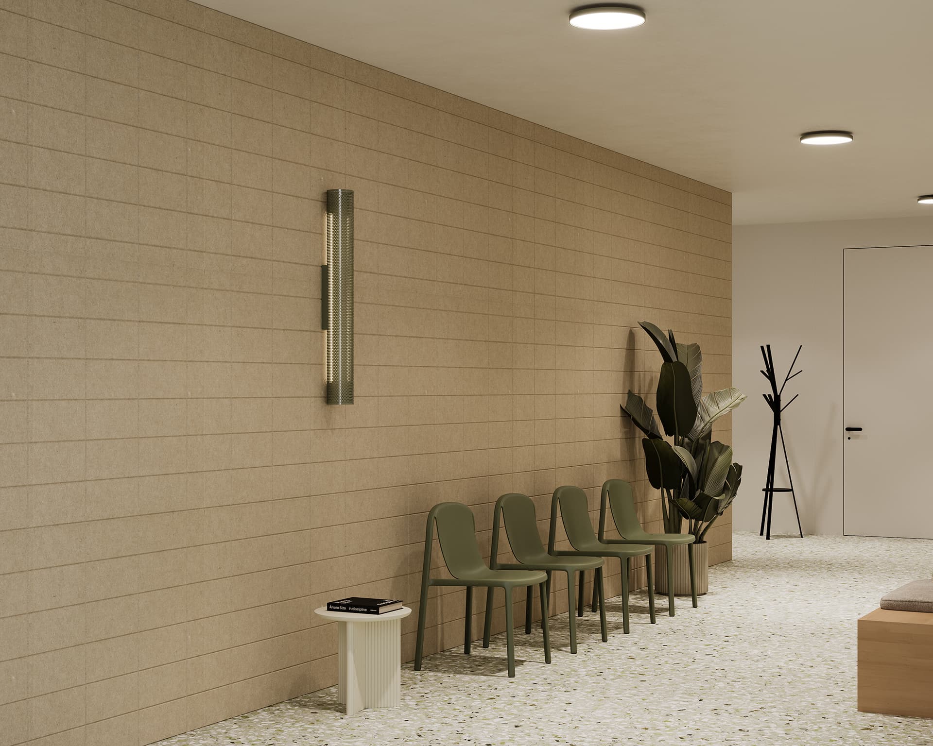 A minimalist waiting area features four green chairs lined against a beige tiled wall. A small white table with a magazine stands near the chairs. A modern wall light and a large potted plant enhance the space. A black coat rack is positioned near a closed white door.