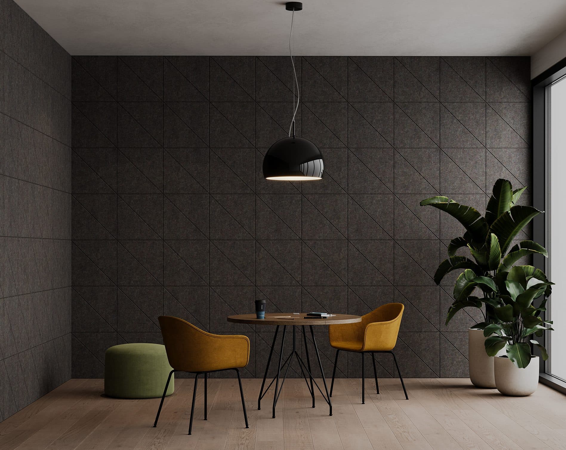 A modern, minimalist dining area with two mustard yellow chairs, a round wooden table, and a green ottoman, all on light wooden flooring and accented with an acoustic felt wall panel. A black pendant light hangs overhead, and a large plant in a white pot stands by a large window, illuminating the room.