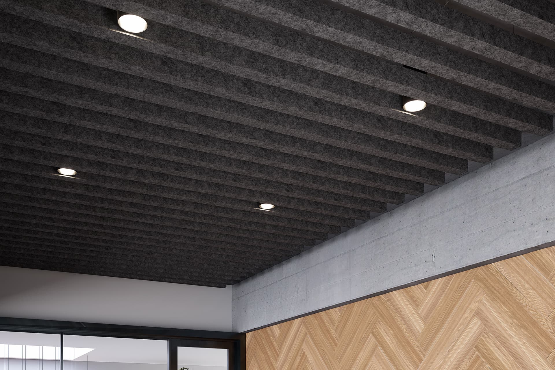 A modern interior ceiling with exposed dark gray acoustic felt baffles and multiple circular recessed lights. Below the ceiling is a wall featuring a chevron-patterned wood panel and a portion of a concrete wall. Part of a glass partition is visible on the left side.