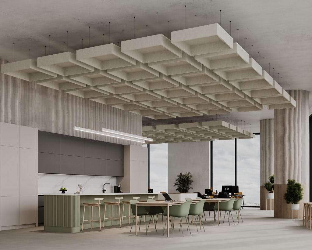 A modern office space features a large kitchen island with green chairs and minimalist decor. Above, a unique grid-patterned ceiling design stands out. To the right, desks with computers and plants adorn the workspace, all illuminated by ample natural light through large windows.