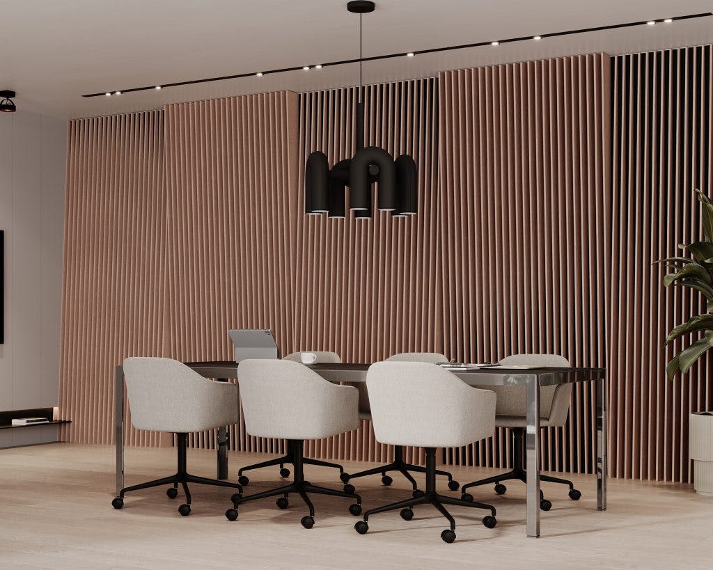 A modern conference room features a sleek glass table with four beige cushioned chairs on casters. The backdrop is elegant acoustic felt panels, and a contemporary black pendant light hangs from the ceiling. A plant sits in the corner, adding a touch of greenery.