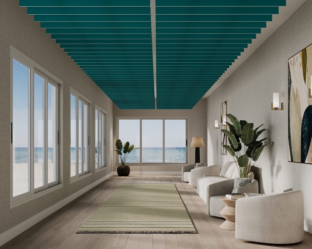 A modern living space featuring a large window wall with an ocean view. The room has white armchairs, a green rug, potted plants, and contemporary wall art. The ceiling features turquoise acoustic felt baffles, adding a vibrant touch to the neutral-toned room.