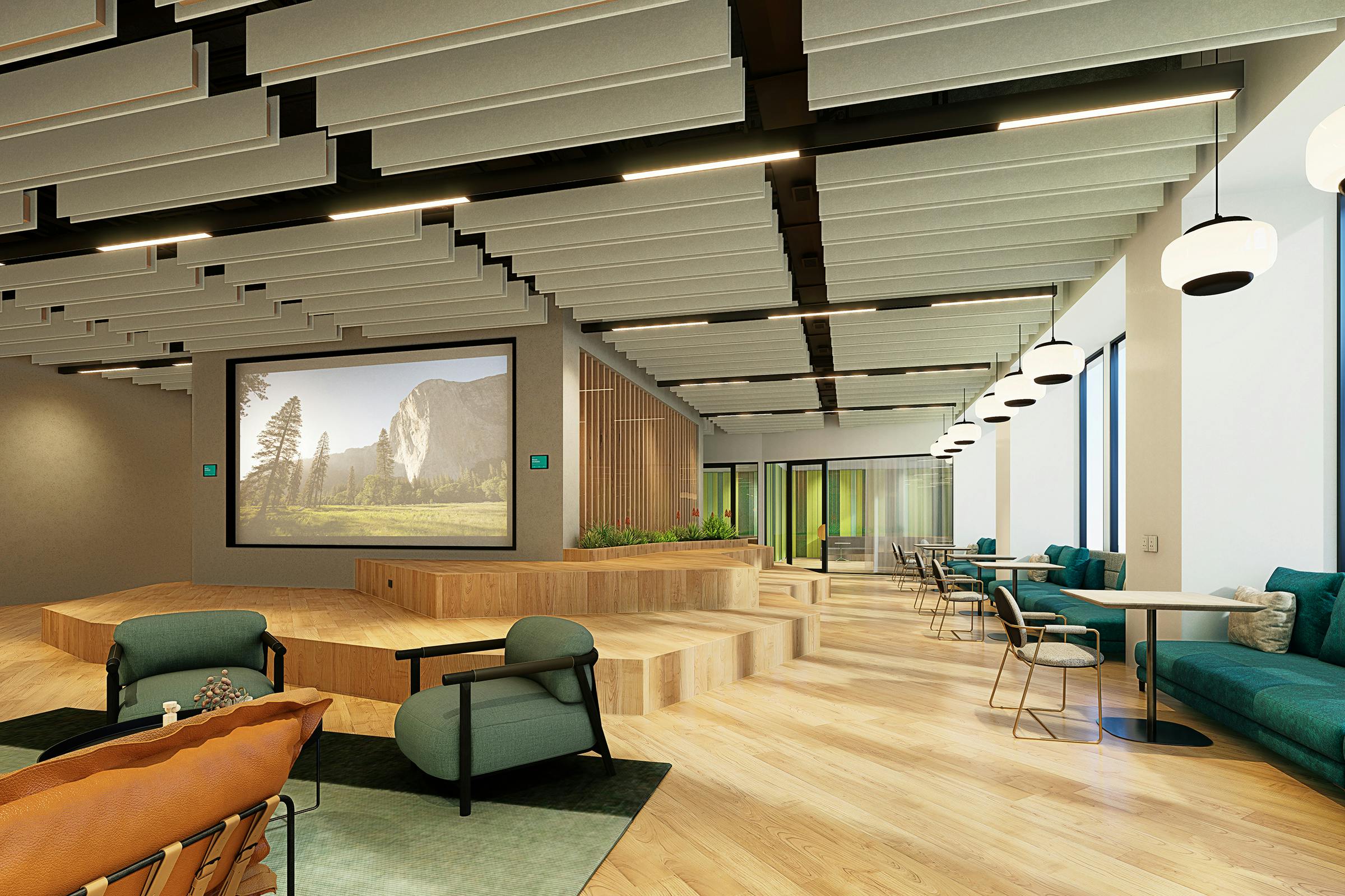 Modern office lounge area with comfortable seating, acoustic ceiling baffles, and a large nature-themed screen.